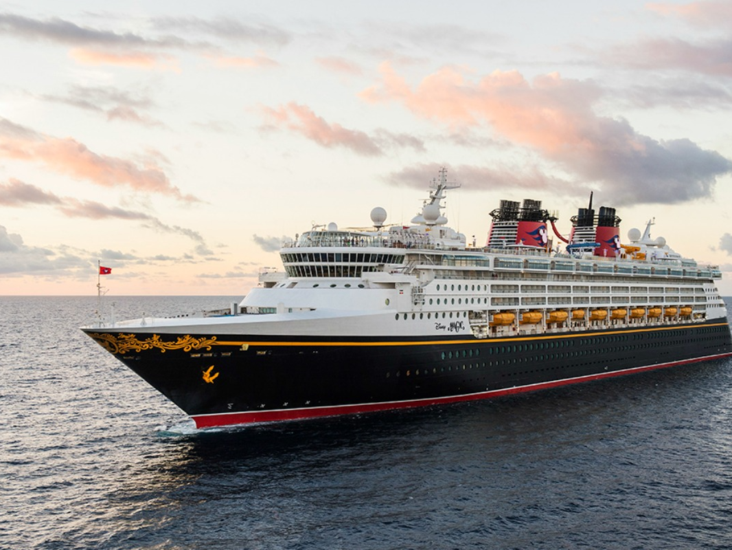 The Disney Magic cruise line sailing on the waters at dusk.