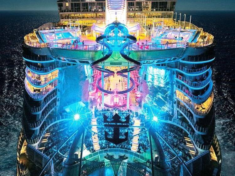 Colorful lights from the Harmony of the Seas ship from the Royal Caribbean International glow in the evening.